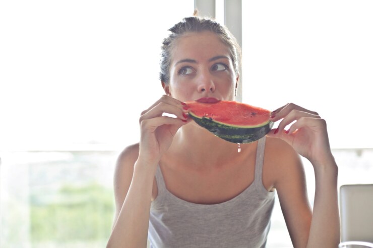 Mulher adulta a comer melancia